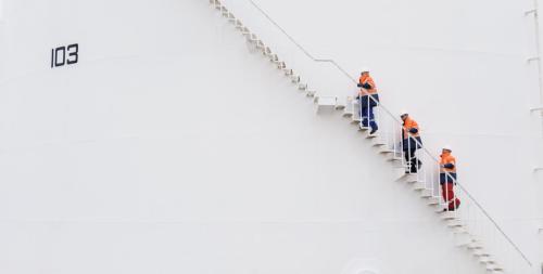 A photo of 3 men in work clothes climbing a staircase